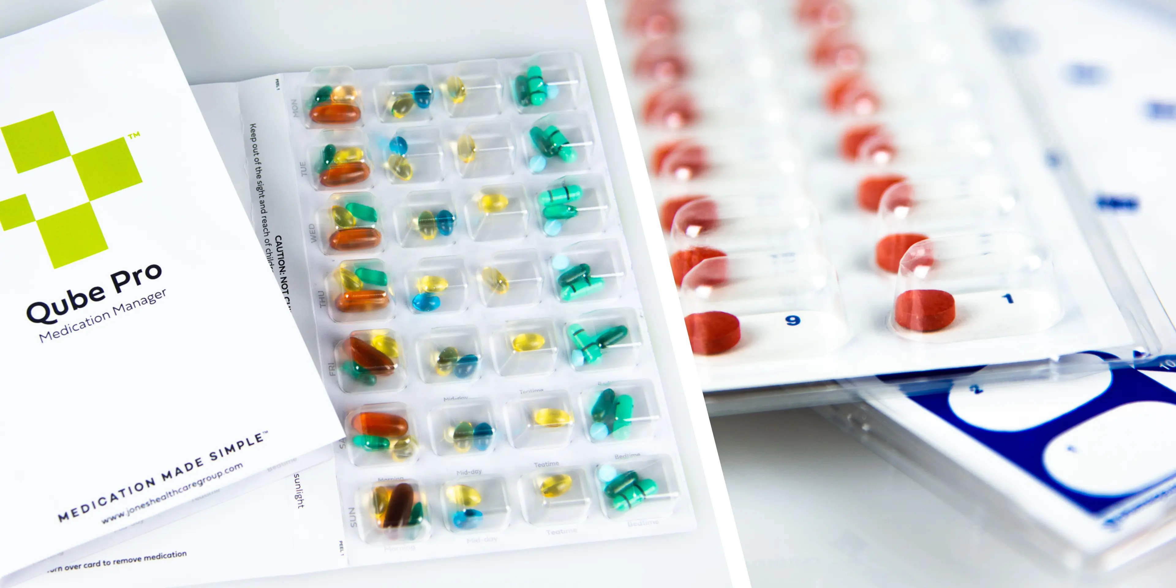 Close-up of Qube Pro medication blister packs featuring a variety of colorful capsules and tablets, organized by time of day, with the Qube Pro Medication Manager brochure prominently displayed, highlighting the benefits of Centralized Fulfillment for Pharmacy.