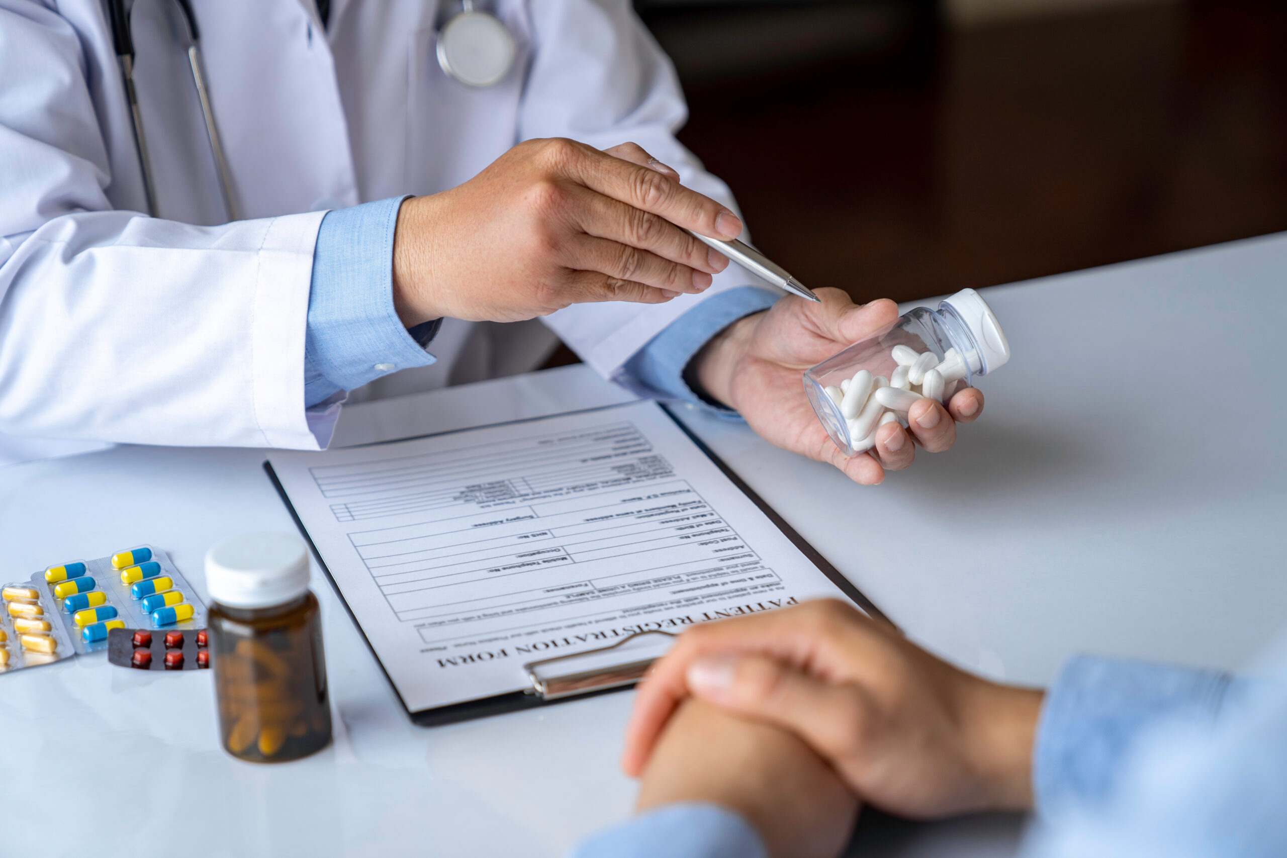 A healthcare professional holding a pack of medications, surrounded by medication packaging, intended to help the treatment of obesity and diabetes. 