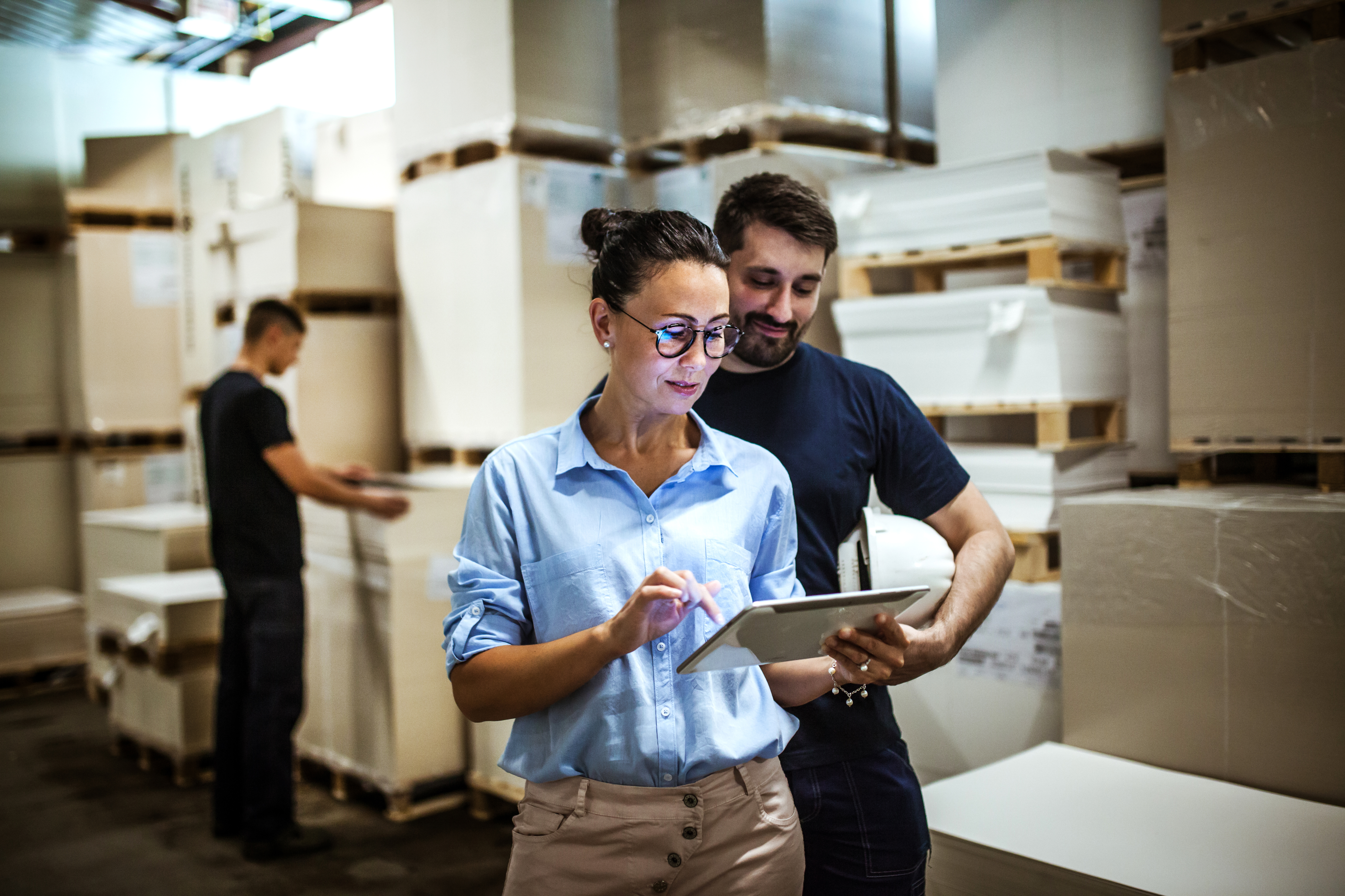 Warehouse supervisor walking and talking with senior manager, actively managing the packaging supply chain.
